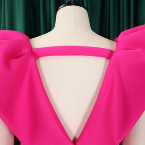 Detalle del vestido fucsia con escote profundo en V en la espalda y hombros abullonados