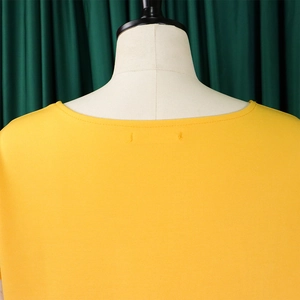 Close-up of bright yellow round neck top fabric texture and clean neckline stitching