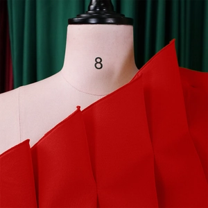 Macro detail of red ruched fabric with layered ruffles on a plus size formal dress