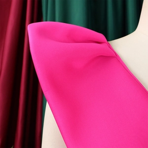 Detalle de hombro abullonado plisado y tela de seda magenta en un vestido formal