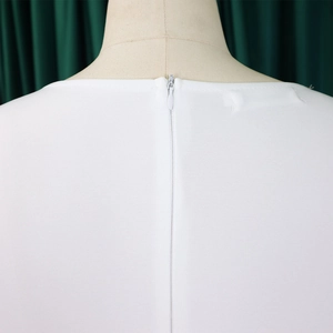 Macro detail of high-quality white dress showing invisible zipper and back neckline texture