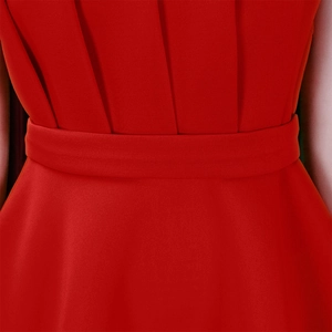 Close-up of red pleated waist detail and elegant tailoring on the cocktail dress