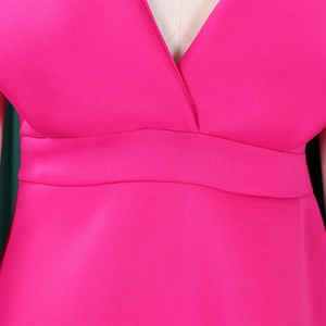 Detalle de escote en V profundo y talle alto en vestido de fiesta fucsia de talla grande