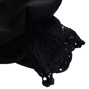 Detailed macro view of black lace embroidery and satin texture on the mermaid dress