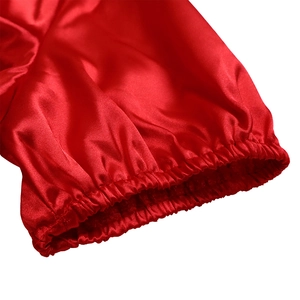 Close-up of bright red satin fabric sleeve with elastic cuffs and pleated texture details