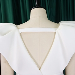 Detalle de escote en V profundo y espalda abierta en vestido de satén blanco