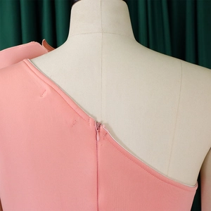 Detail shot of invisible back zipper on a pink one-shoulder formal evening dress