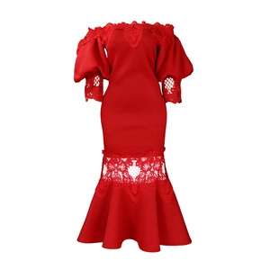 Detail of red off-shoulder lace dress showing intricate floral embroidery and fishtail hem