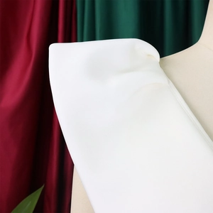 Detalle del hombro del vestido blanco y tejido liso sobre un maniquí de costura
