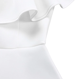 Détail macro des volants blancs et du tissu texturé sur une robe de soirée chic