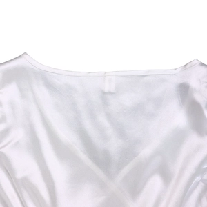 Detailed close-up of V-neck stitching and silk texture on a white summer dress