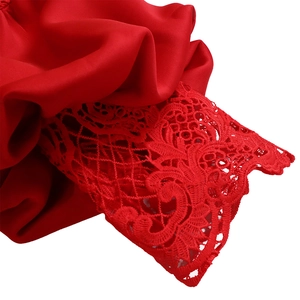 Detailed close-up of the red dress showing intricate lace crochet and silk fabric textures