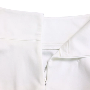 Detail of white two-piece set featuring concealed zipper and precise double-stitch waist