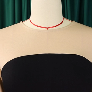 Dettaglio dell'abito in maglia bicolore con inserti beige e neri e scollatura rotonda