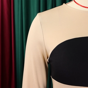 Dettaglio delle eleganti cuciture patchwork beige e nere sulla spalla dell'abito in maglia