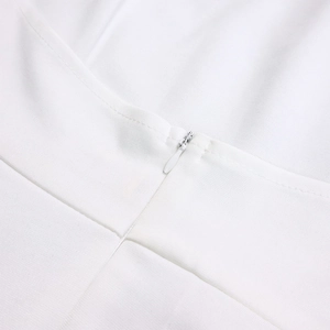 Macro view of white invisible zipper and textured fabric detail on back of summer outfit