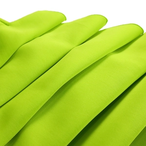 Macro shot of neon green fabric showing pleated texture and neat edge stitching detail