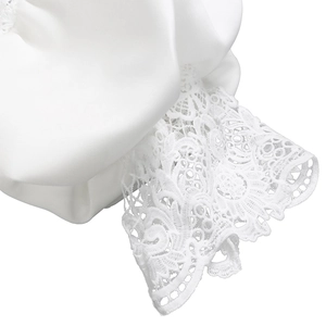 Macro shot of white lace texture and smooth satin fabric detail on the evening dress