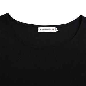 Close-up of the black crew neck top neckline showing fine knit fabric and the M size tag