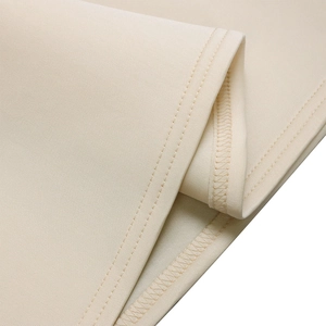 Detalle de costura de dobladillo de doble aguja y remallado en tela de vestido beige