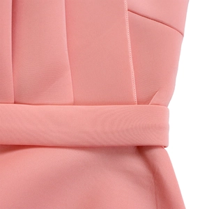 Detailed macro view of the horizontal pleated texture on a pink high-waist evening dress