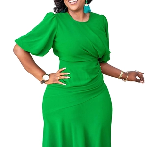 Detail of emerald green bodycon dress with puff sleeves and waist pleats on a model