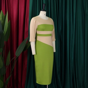 Detail view of knee-length slim fit dress with green and beige color-block design