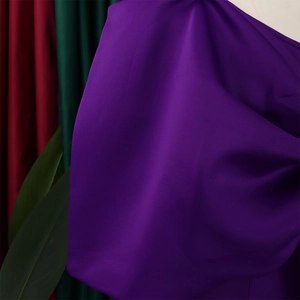 Detail aus elegantem dunkelviolettem Satingewebe mit seidiger Textur und Faltenwurf