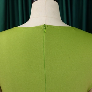 Detail of invisible zipper closure on green textured dress for precise fit