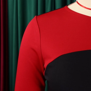 Dettaglio dell'abito color-block rosso e nero che mostra la trama della maglia e il collo
