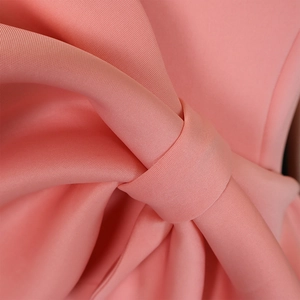 Detail eines rosa Partykleids mit festem Flachgewebe und 3D-Schleifen-Textur