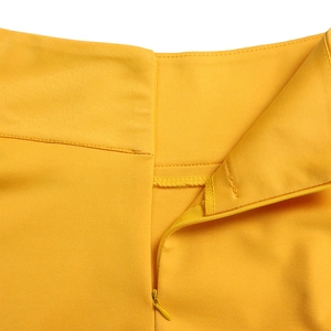 Detail shot of invisible zipper and neat stitching on bright yellow dress waist