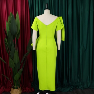 Detailansicht eines neongrünen Abendkleids mit großer Schleife und rückenfreiem V-Ausschnitt