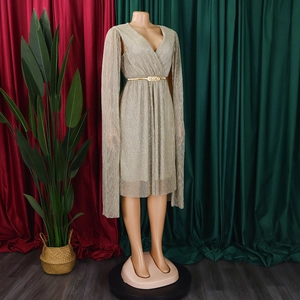 Detail of V-neck gold shimmering dress with cape sleeves and slim metallic waist belt