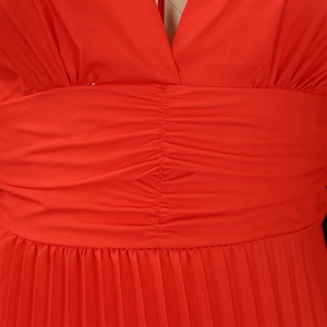 Dettaglio dell'elegante abito lungo rosso con scollo a V e vita a pieghe raffinata