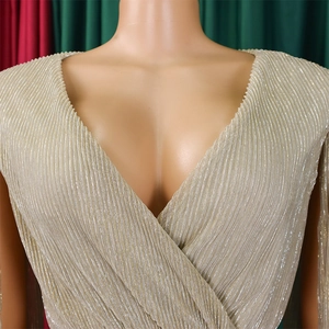 Detail of V-neck champagne gold pleated evening dress with metallic sheen and elegant wrap design