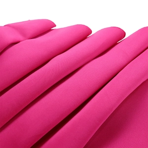Détail du tissu magenta montrant des coutures de qualité et un matériau plissé texturé