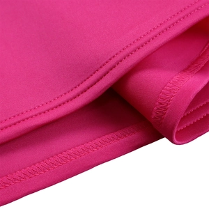 Détail macro du tissu rose vif avec coutures overlock précises et finitions de qualité