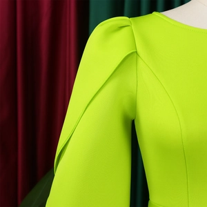 Detail of neon green elegant dress showing structured puff sleeves and neckline stitching