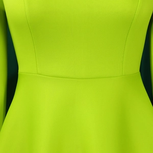 Detail view of the fluorescent green dress with textured vertical ribs and slim waistline