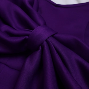 Detaillierte Nahaufnahme einer großen lila Schleife an einem Abendkleid mit feiner Textur