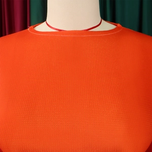 Detail of orange waffle knit fabric texture and round neckline on a mannequin