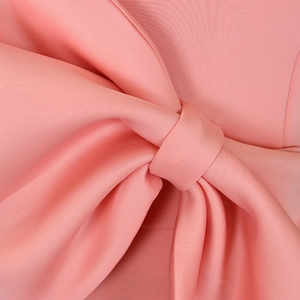 Detailansicht einer großen rosa Schleife an einem eleganten Abendkleid
