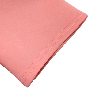 Makro-Detail des rosa Strickstoffs mit Doppelnaht-Verarbeitung und feiner Textur