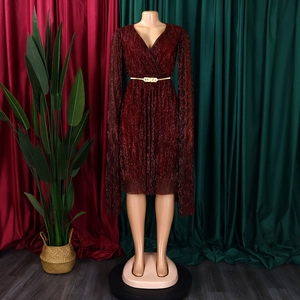 Detail of wine red V-neck dress with long slit cape sleeves and gold metal belt accent