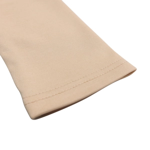 Dettaglio ravvicinato della doppia cucitura su tessuto a maglia beige elasticizzato