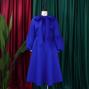 Detail of royal blue dress featuring large bow-tie neckline and puff lantern sleeves