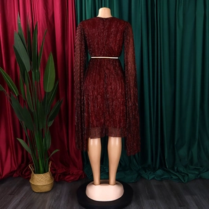 Close-up of wine red glitter dress featuring pleated fabric and a gold metal waist belt