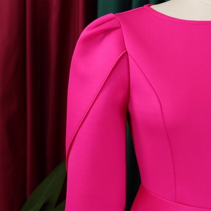 Detail of rose red elegant dress featuring structured puff sleeves and fine stitching