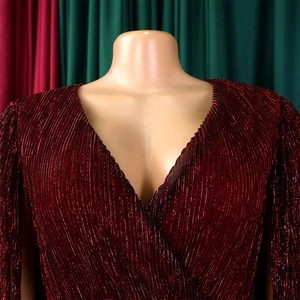 Close-up of elegant V-neck pleated dress with shimmering dark red metallic finish texture
